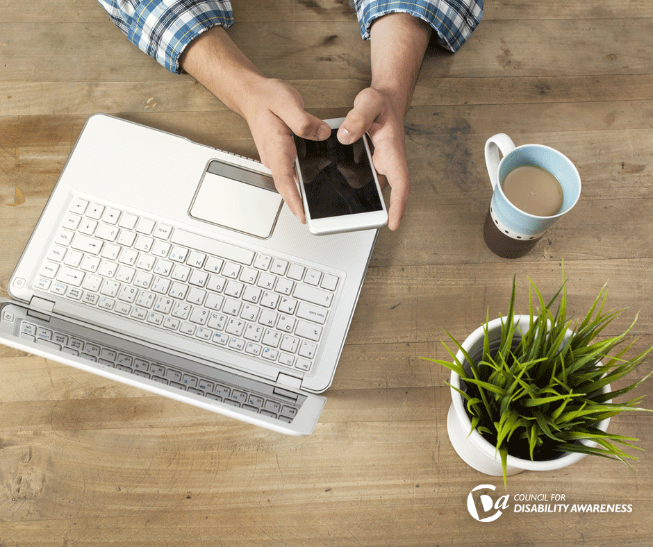 Person at a laptop using their phone