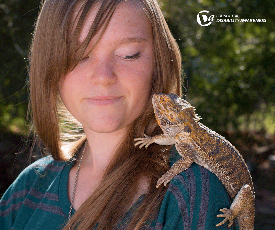 Pet bearded dragon on young woman's shoulder