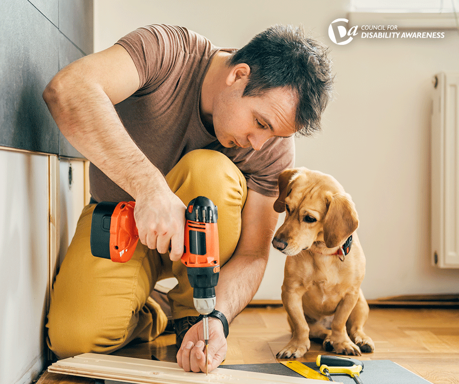 Man drills working on home project while dog watches