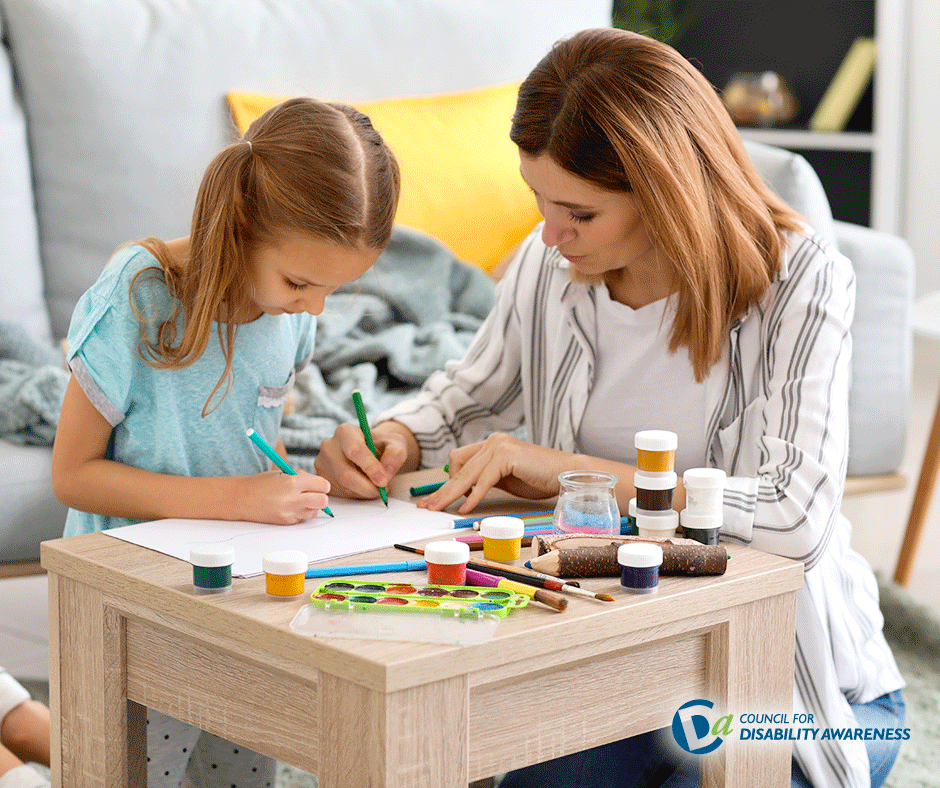 Young girl with disabilities working on an art project with her mother