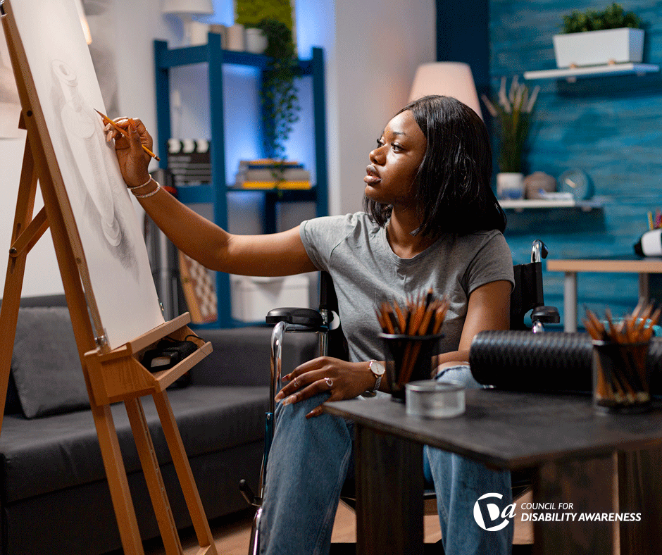 teenage artist in a wheelchair works at an easel