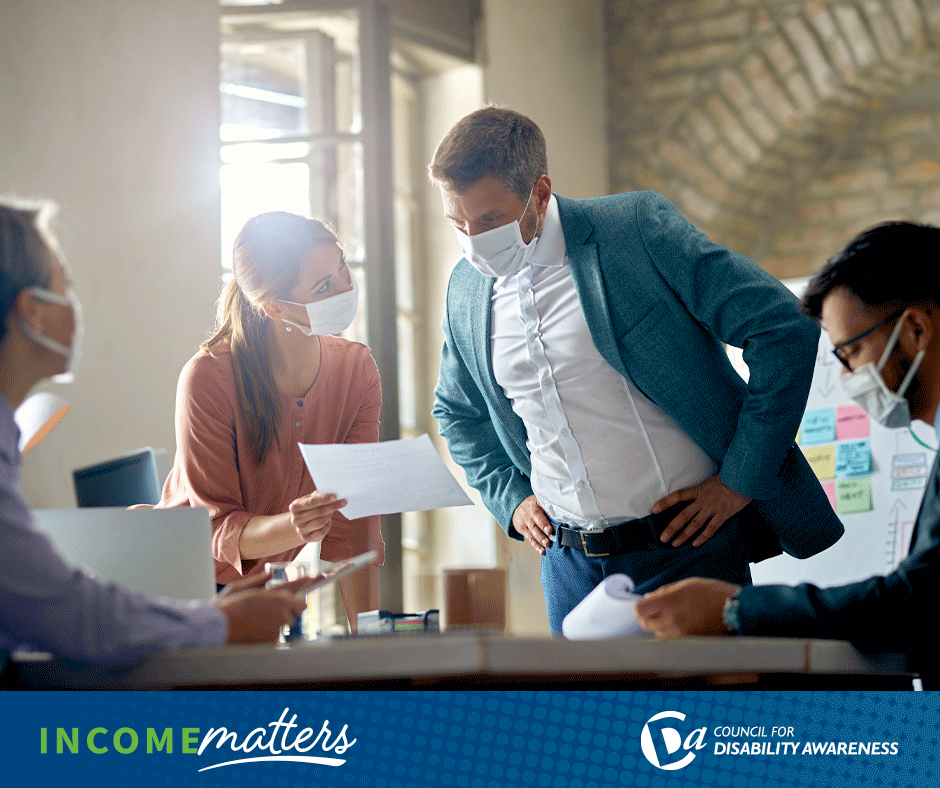 Workers in office setting wearing masks. Income Matters.