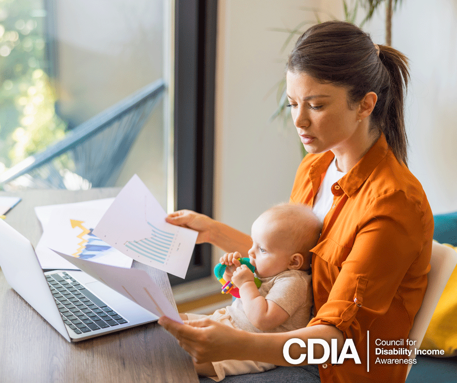 Young mother with her baby, working on a laptop at home